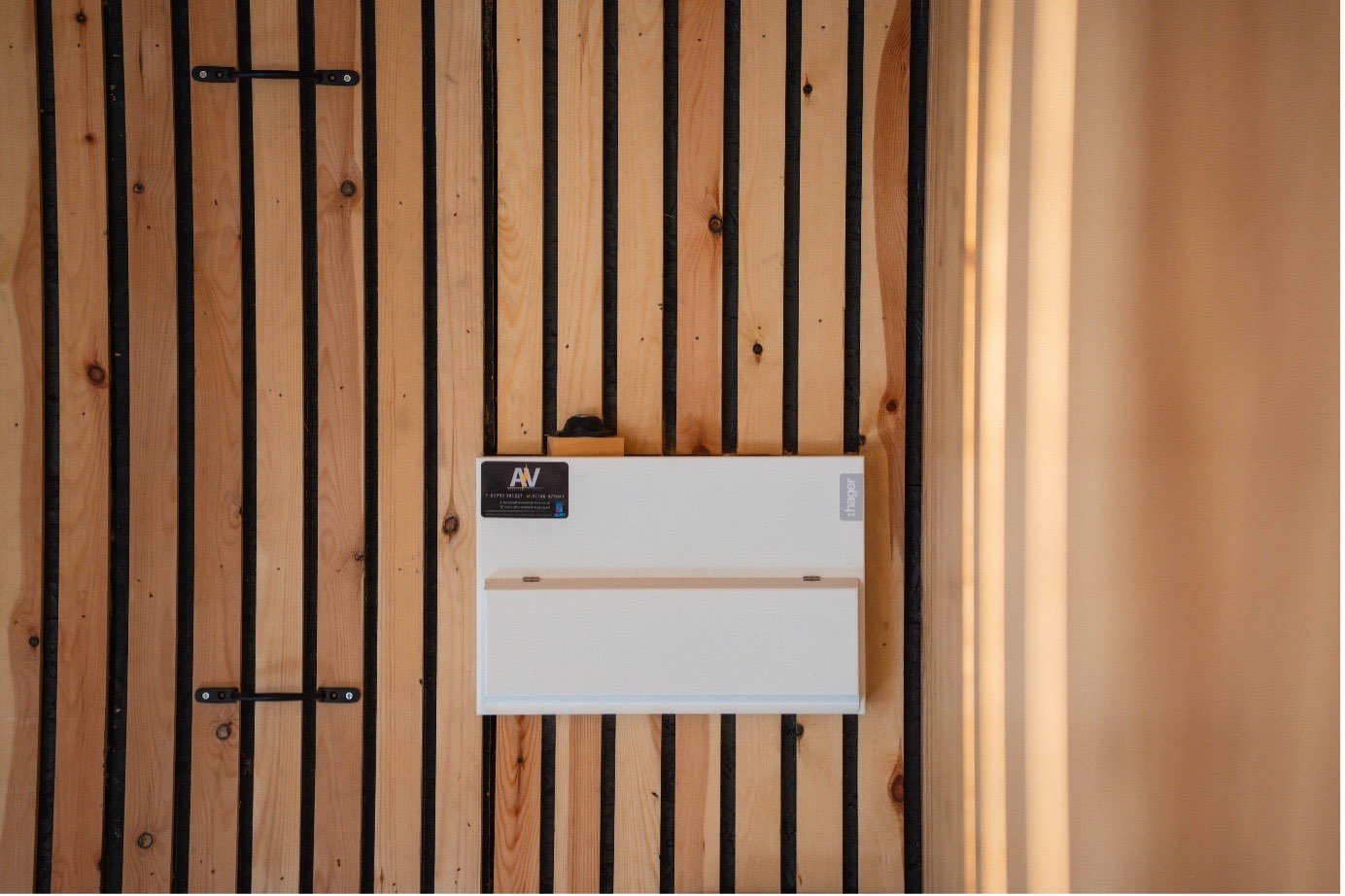 A neatly finished consumer unit on timber cladding after a rewire