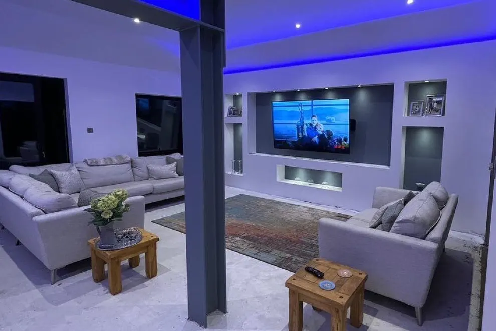 A lounge AV installation with wall-mounted television and discreet speakers