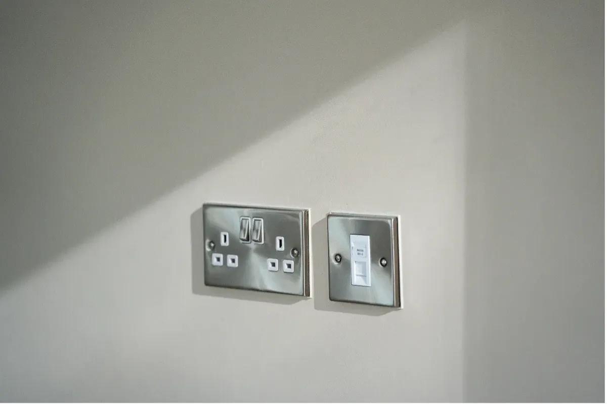 Brushed steel sockets and data plate fitted during a rewire