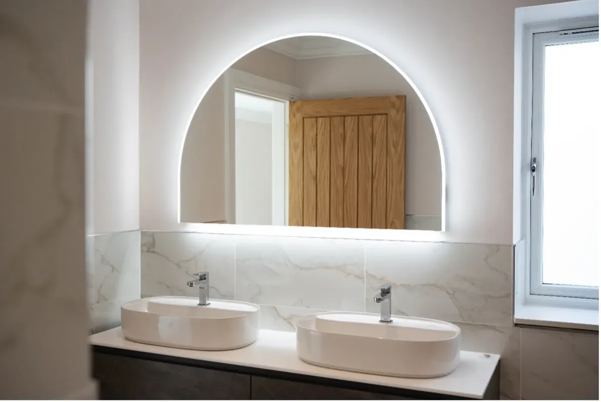 A backlit bathroom mirror over twin basins — notifiable zone work by Allview, certified
